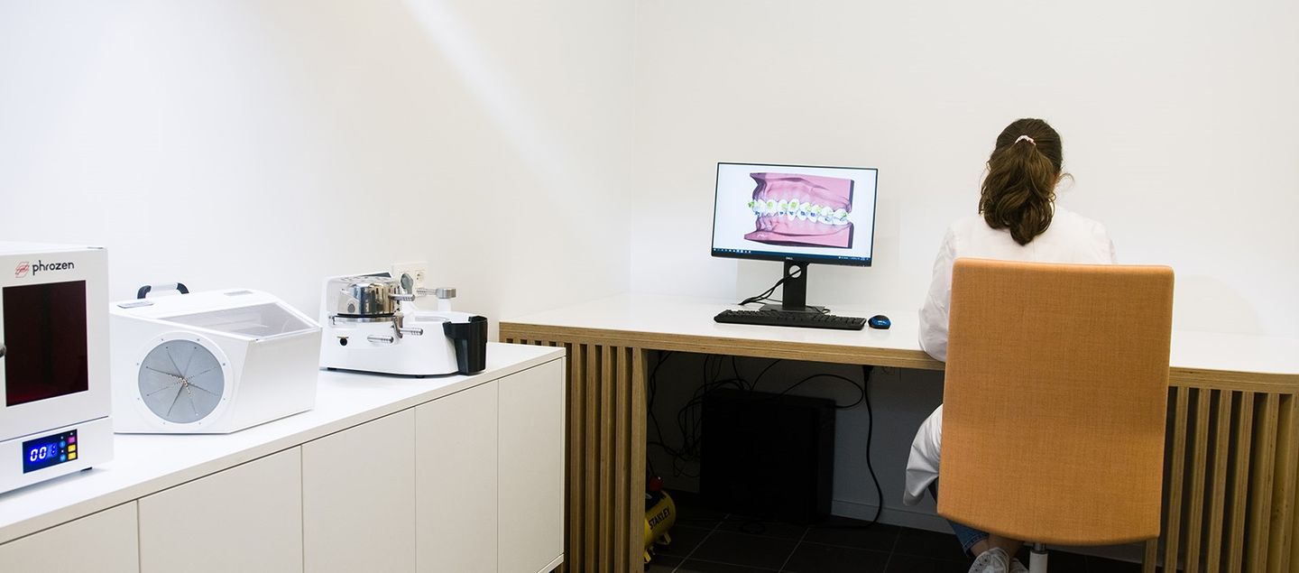 Orthodontist werkt in een labo waar tanden in 3D gemodelleerd worden op de computer om nadien te printen.